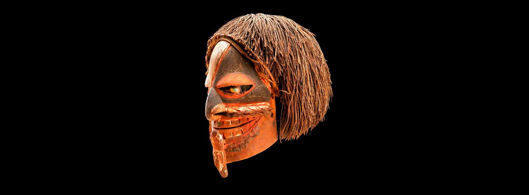 Mask from Northern New Ireland, Papua New Guinea collected by A.W.F. Fuller (originally given to the Chichester Museum by Miss Newman of Midhurst, England in 1859.  This wooden mask, with opercula eyes, fiber hair, and painted with red ochre, lime, and black pigment, is one of the earliest known masks from New Ireland.  Catalog Number 2616.276499. Photo Archives ID # A114455_02d.