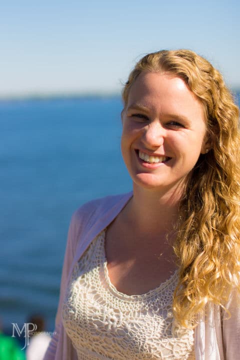 A woman with long wavy blonde hair, smiling.