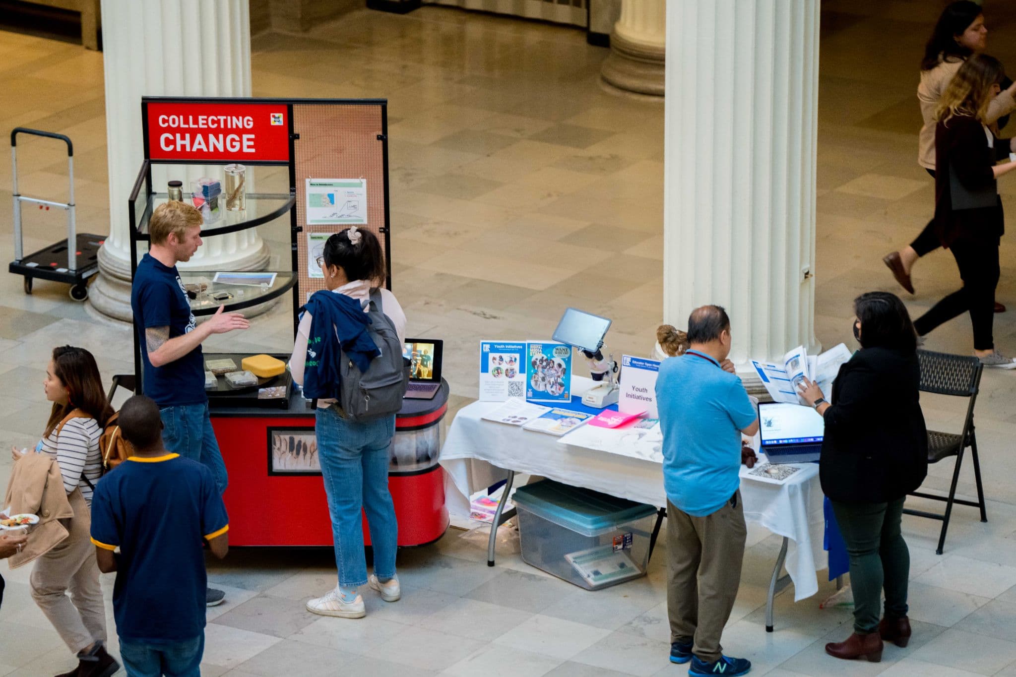 Museum staff engage with visitors at stations set up in the main hall.