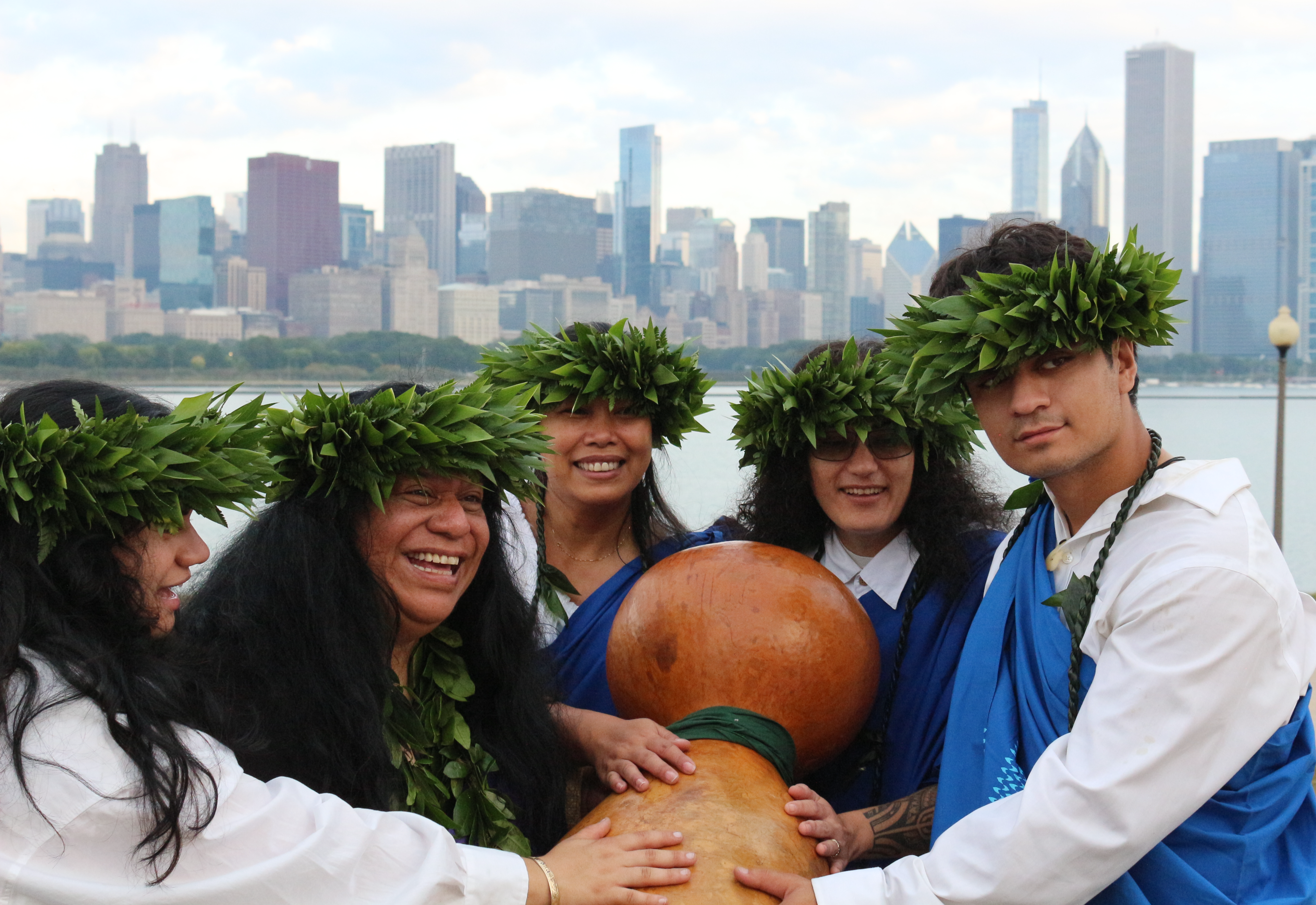Five Hula practitioners, gathered together in front of the Chicago skyline.
